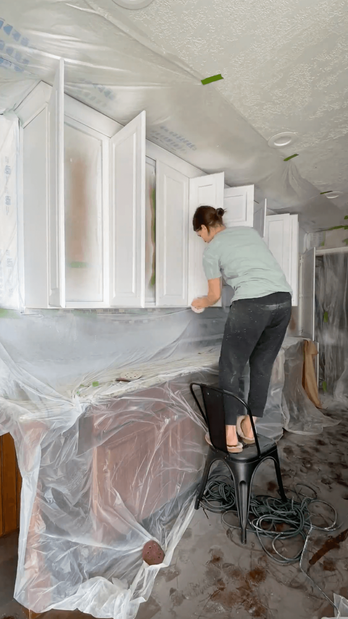 Sanding after priming kitchen cabinets.